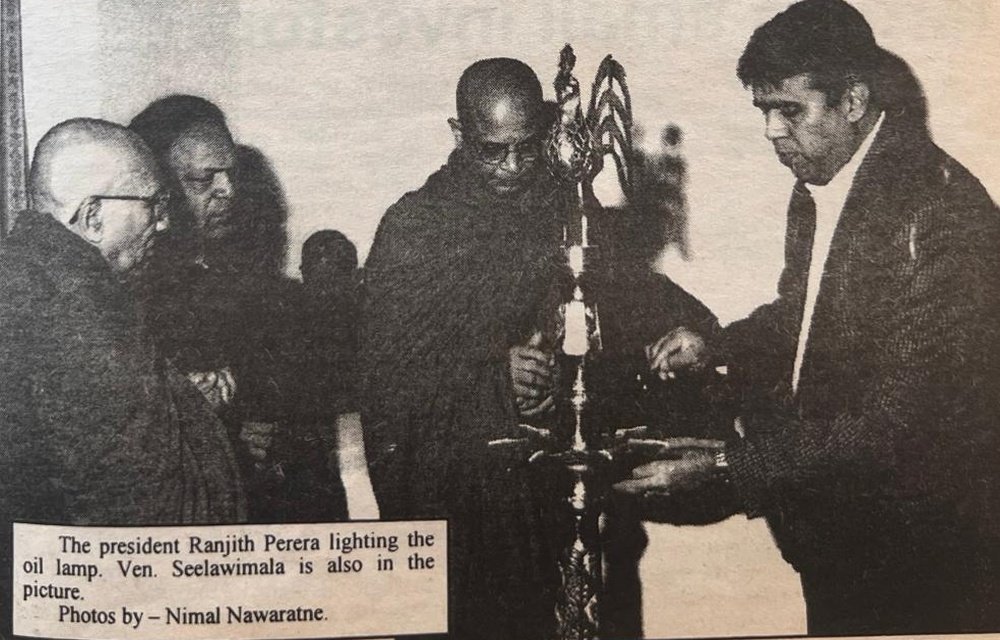 The president, Ranjith Perera, lighting the oil lamp, with Venerable Seelawimala beside him